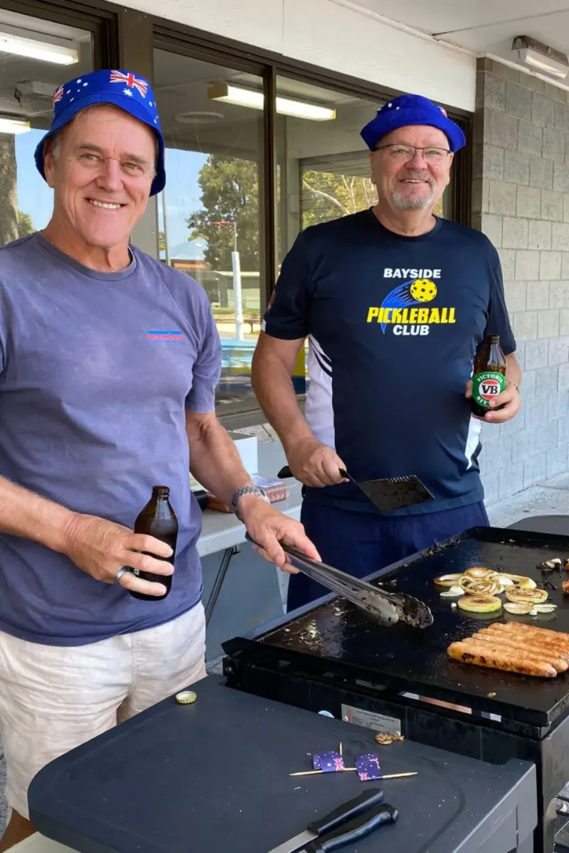 Bayside Pickleball Club members cooking together at an outdoor club barbecue